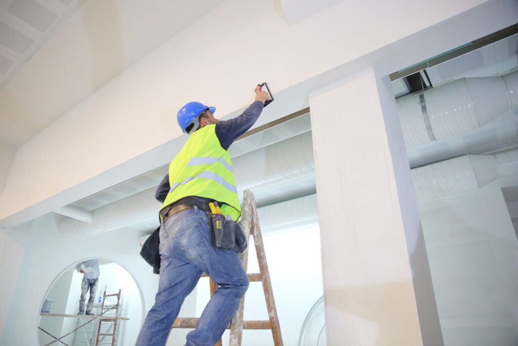 Plaster applying plaster on a new drywall installation